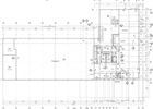 Architectural blueprint with lines, numbers, and symbols depicting a building floor plan.
