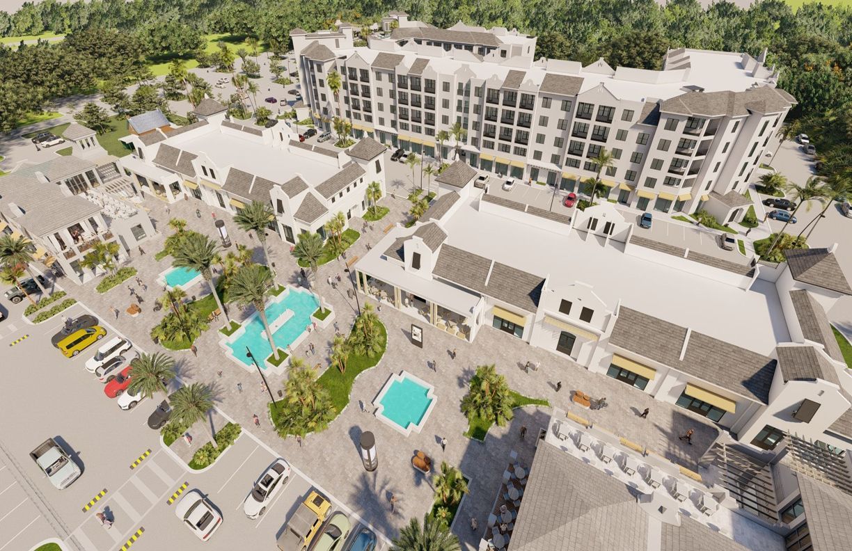 Aerial view of a mixed-use development with retail shops, apartments, and a central plaza with pools.