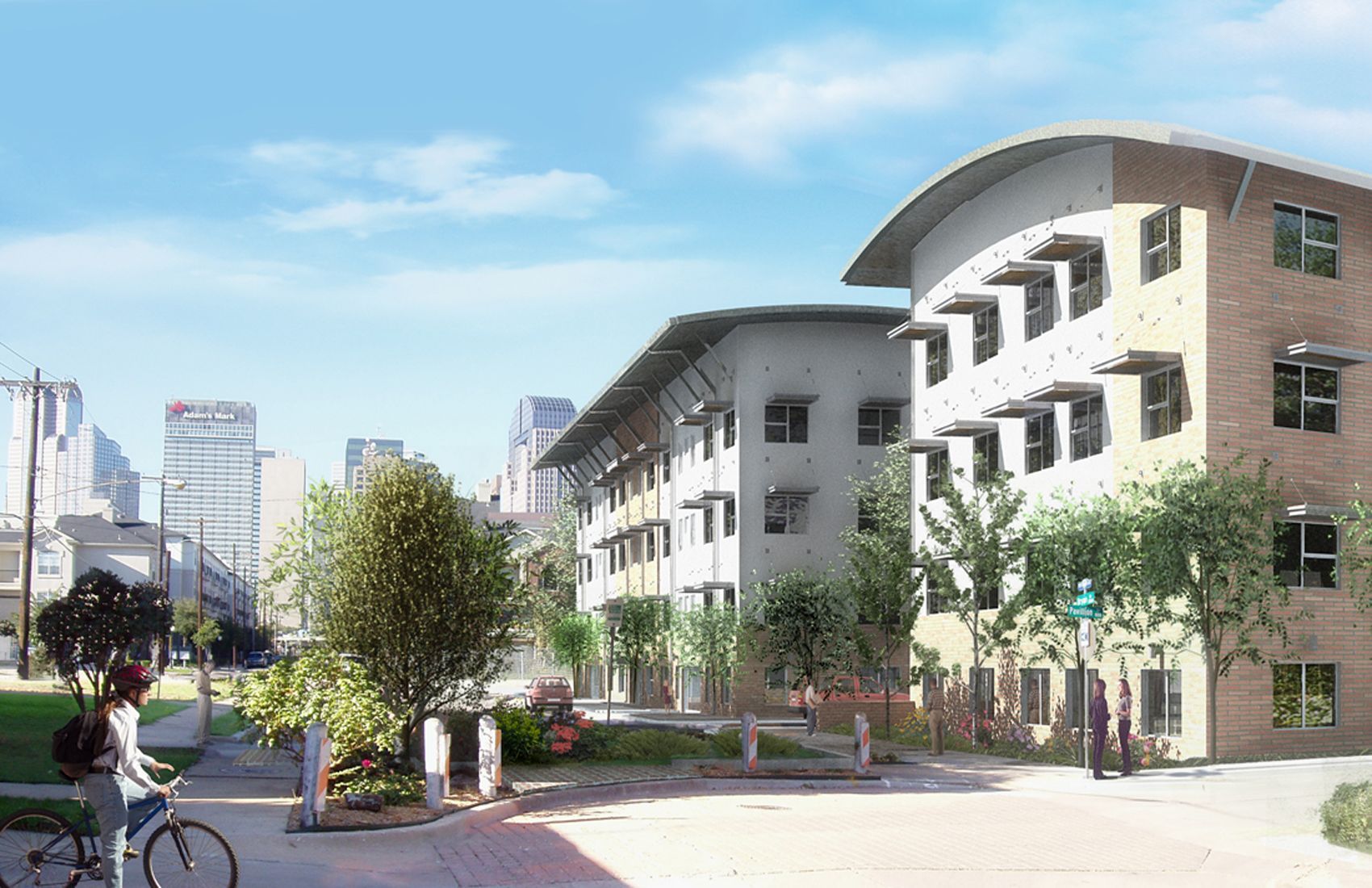 Buildings and green space in a city. Person on a bike. Clear sky.
