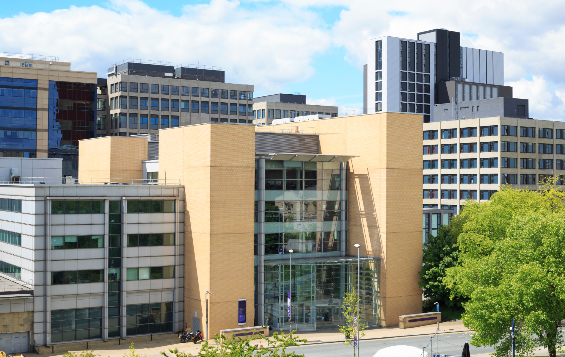A large building with a lot of windows is surrounded by other buildings