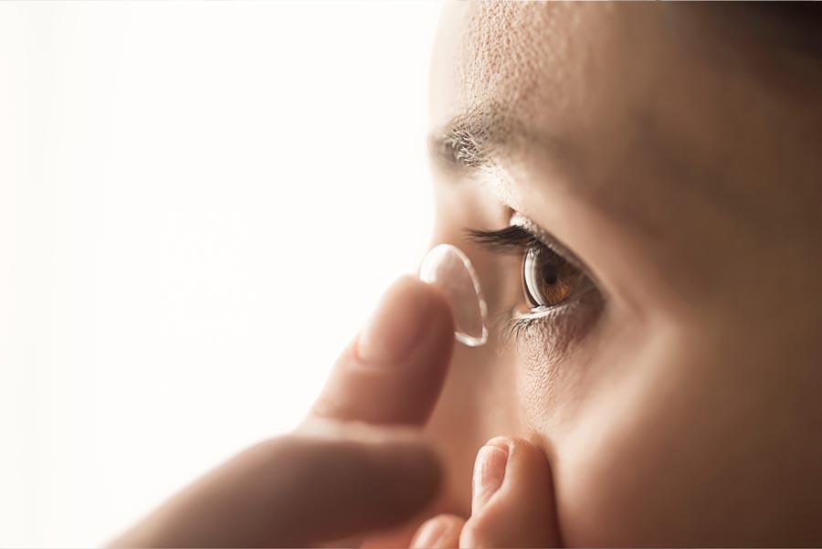 Contact Lenses — Woman Putting Contacts in Her Eyes in Springdale, AR Contact Lenses — Woman Putting Contacts in Her Eyes in Springdale, AR