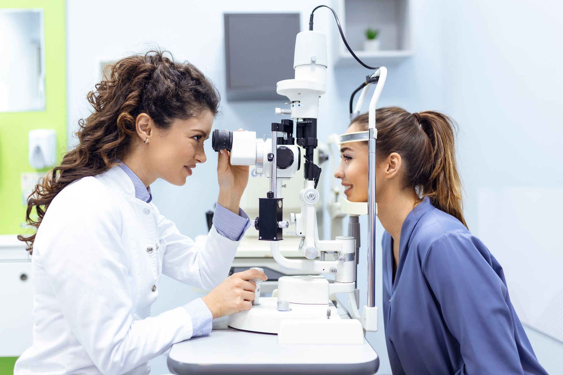 An eye doctor uses a slit lamp to closely examine a patient’s eyes.