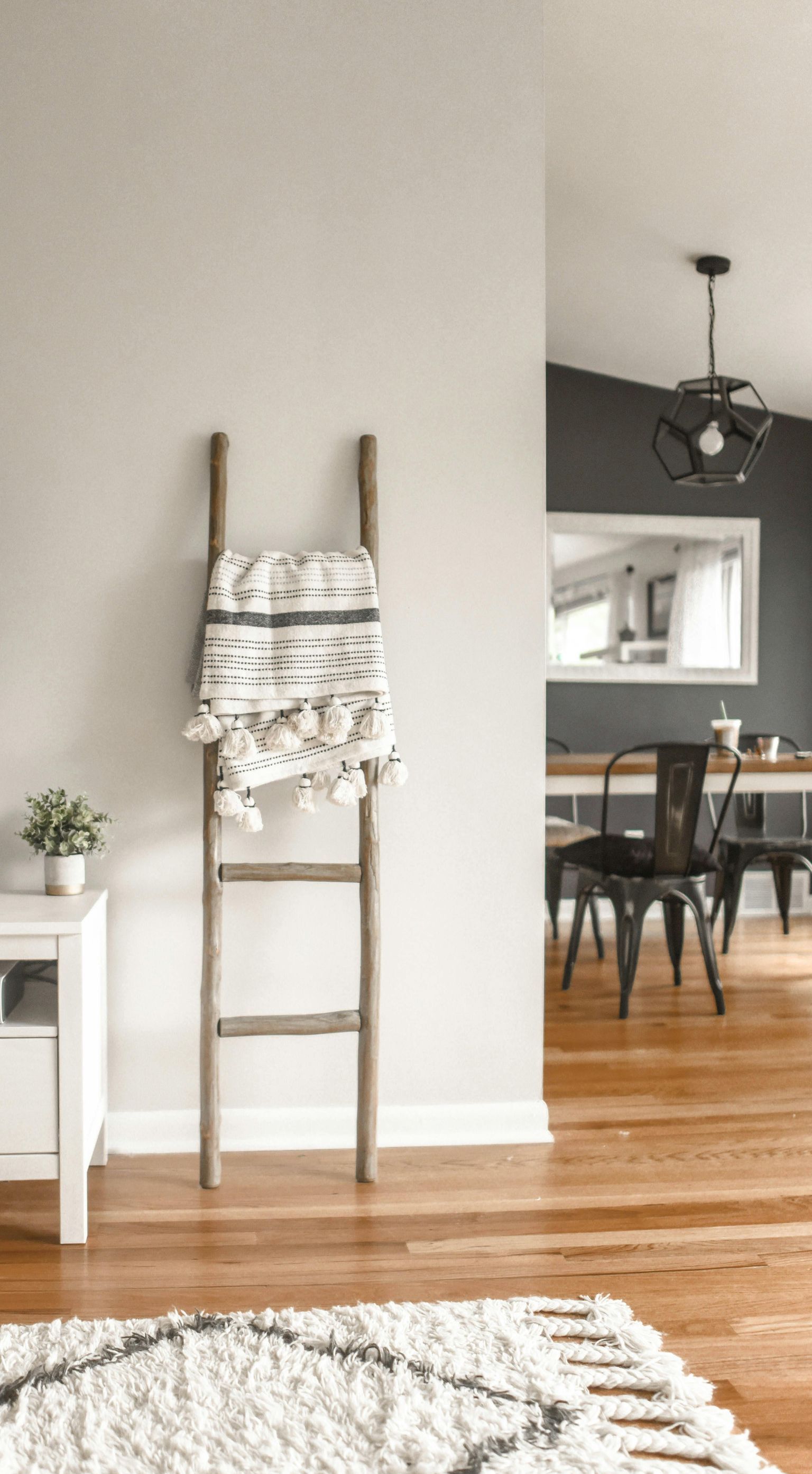 A wooden ladder with a blanket on top of it in a living room.