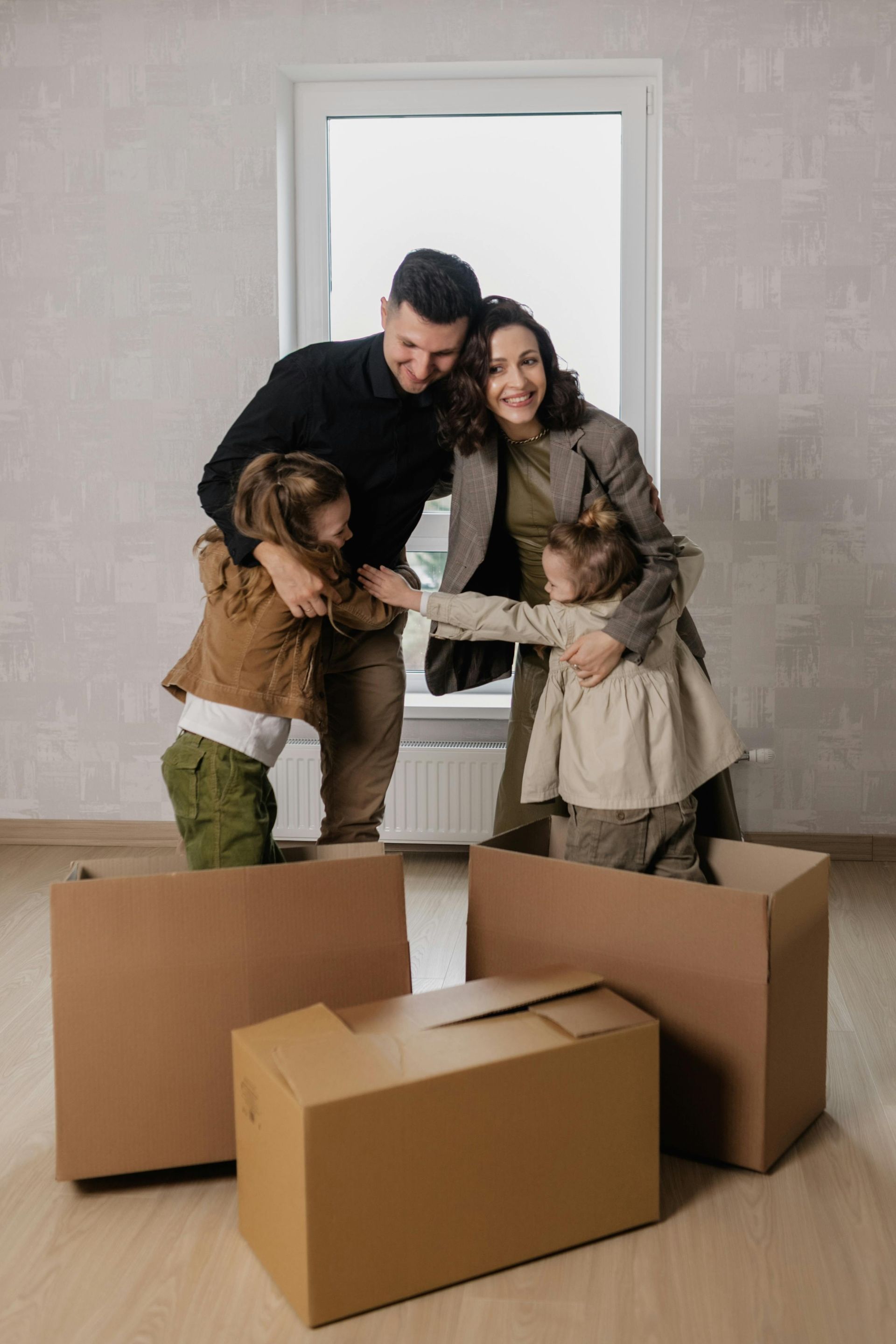 A family is playing with cardboard boxes in their new home.