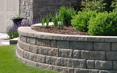 Curved stone retaining wall with green shrubs and plants in a landscaped garden