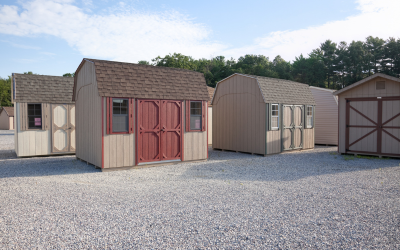 Row of small storage sheds on a gravel lot under a clear sky