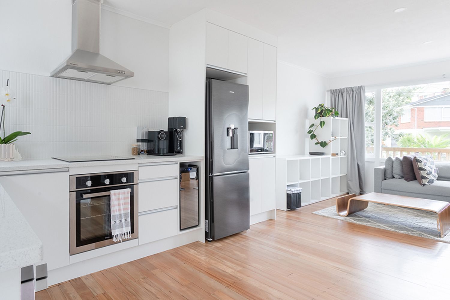 A kitchen with a stainless steel refrigerator and a stove top oven.