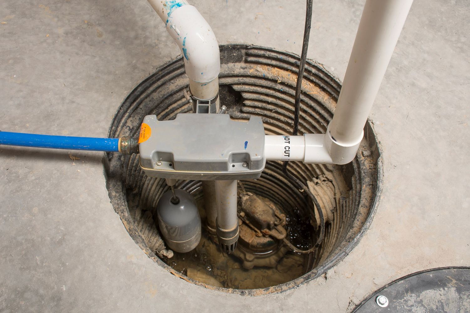 A close up of a sump pump in a basement.