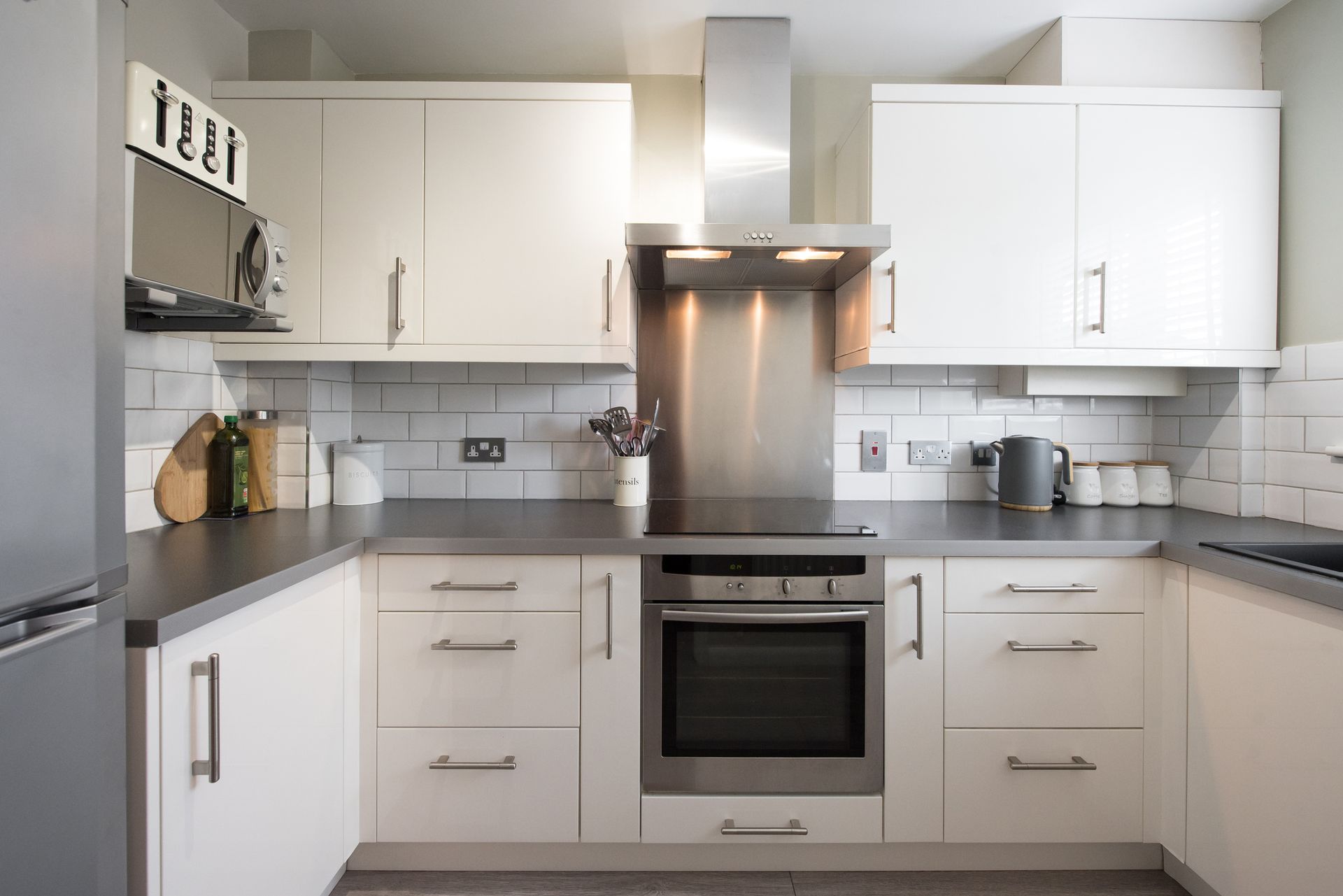 A kitchen with white cabinets and stainless steel appliances