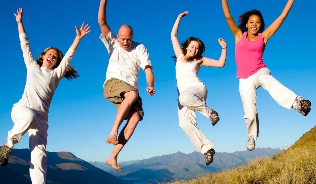 A group of people are jumping in the air with their arms in the air