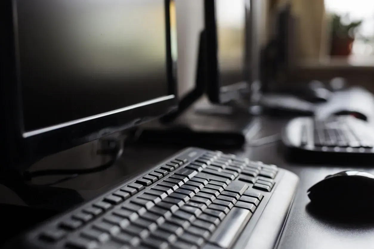 A keyboard and mouse are on a desk in front of a computer monitor