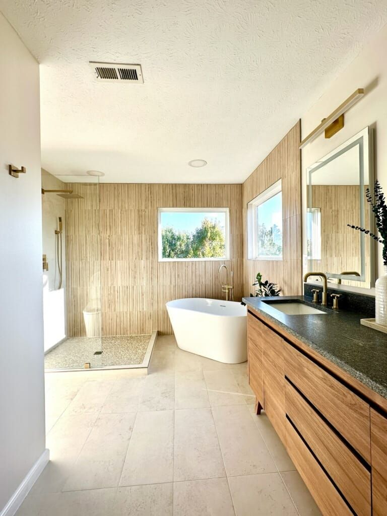 Modern bathroom with wood-look tiled walls, a white freestanding tub, a large walk-in shower.