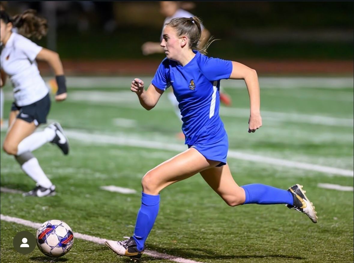 Two players going after a soccer ball