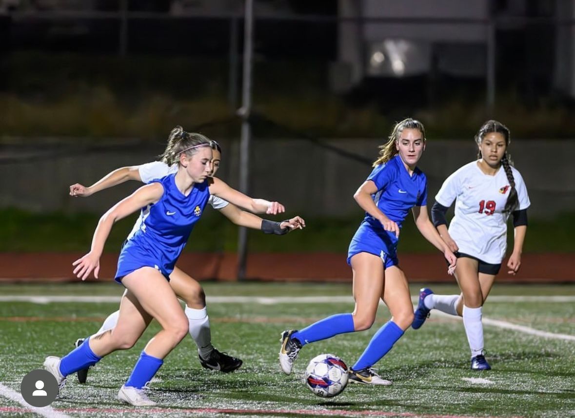 Two players going after a soccer ball