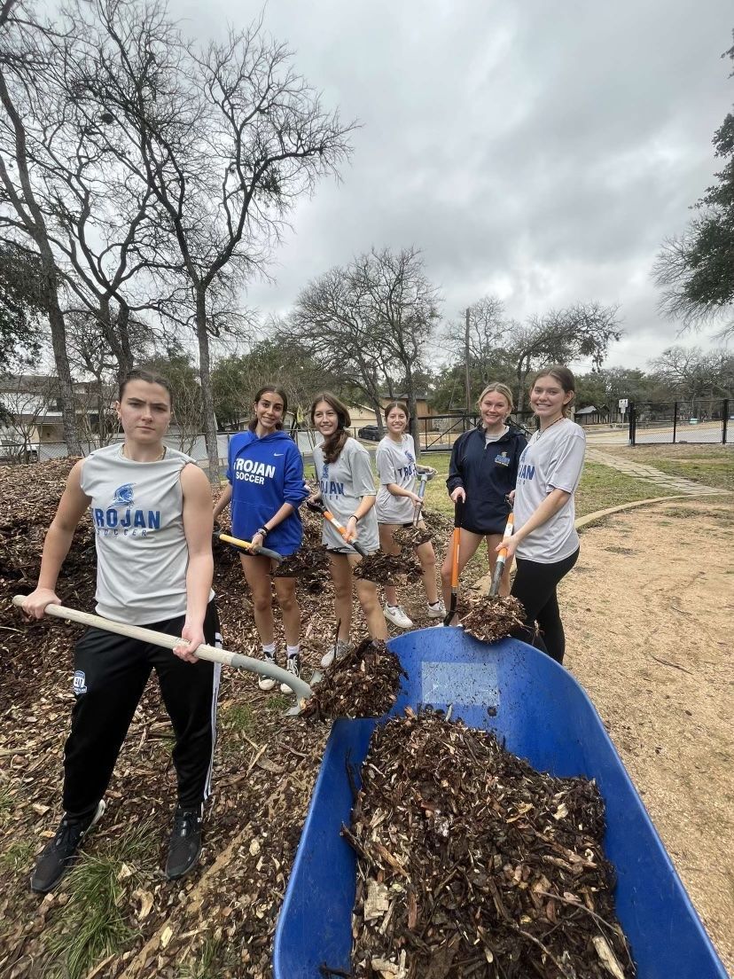 Anderson soccer players working on a service project - gardening.