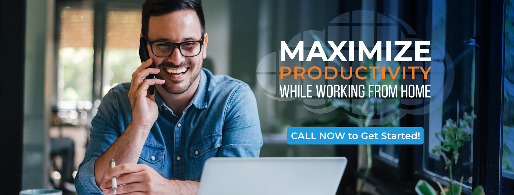 A man is sitting in front of a laptop computer talking on a cell phone.