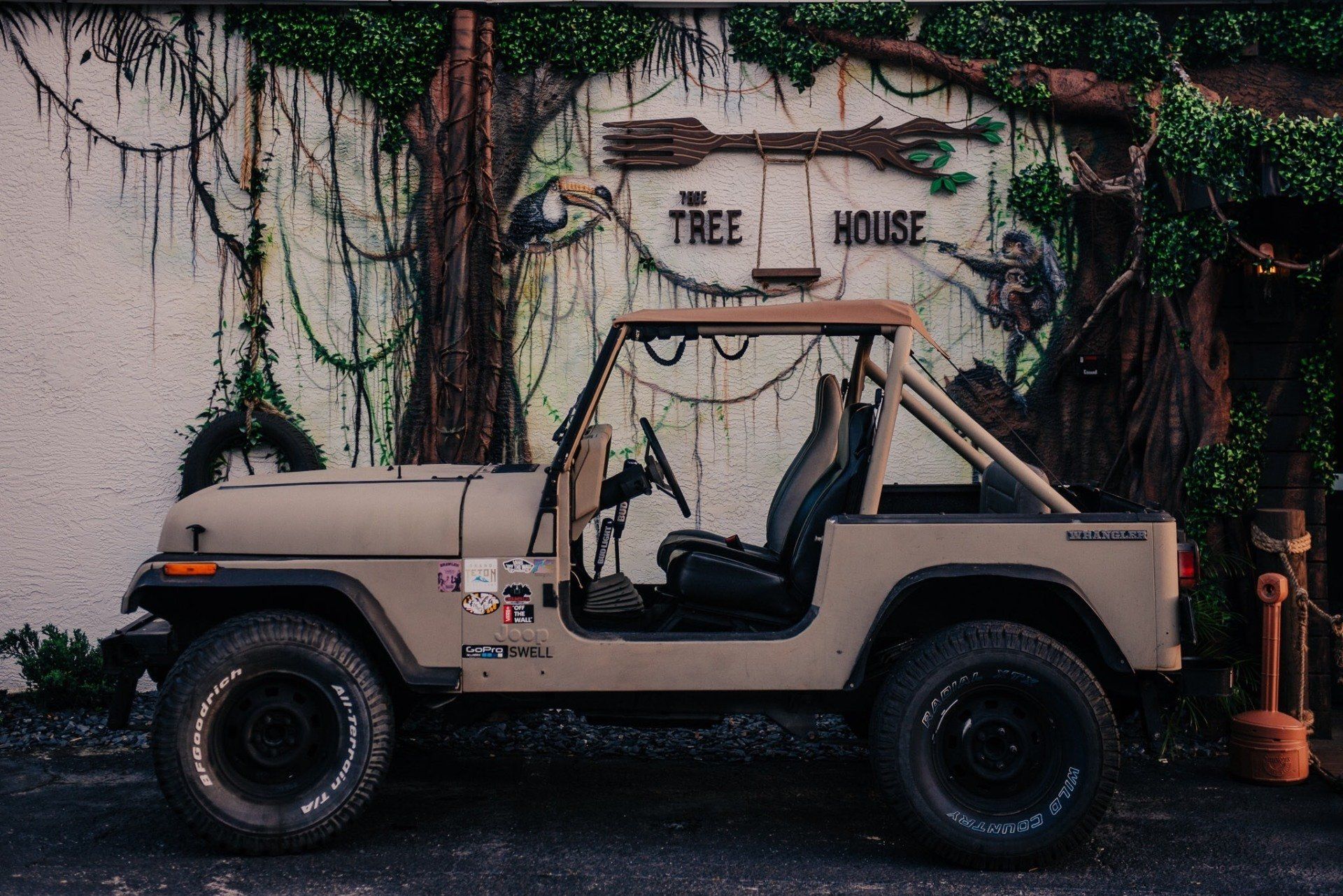 A jeep is parked in front of a tree house