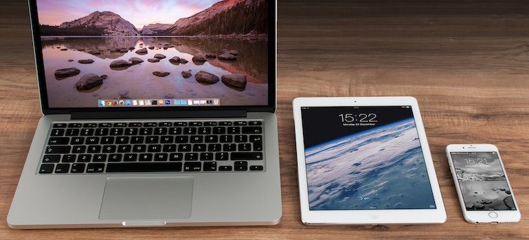 a laptop, tablet, and smartphone on the table