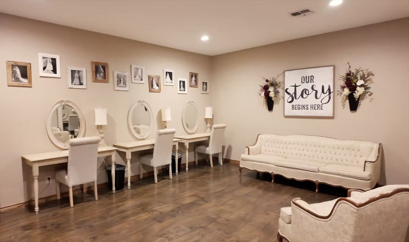 A bridal suite with vanities, mirrors, seating, and framed photos on a beige wall.