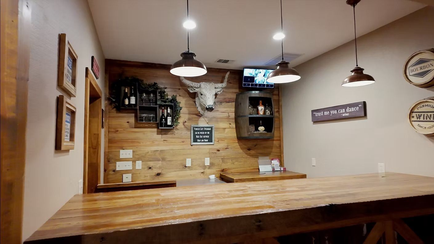 Rustic bar with wood accents, bull skull, and pendant lights.
