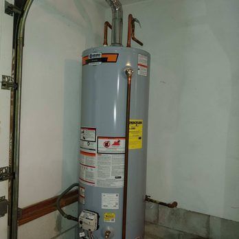 A group of men in red shirts and black pants are posing for a picture.