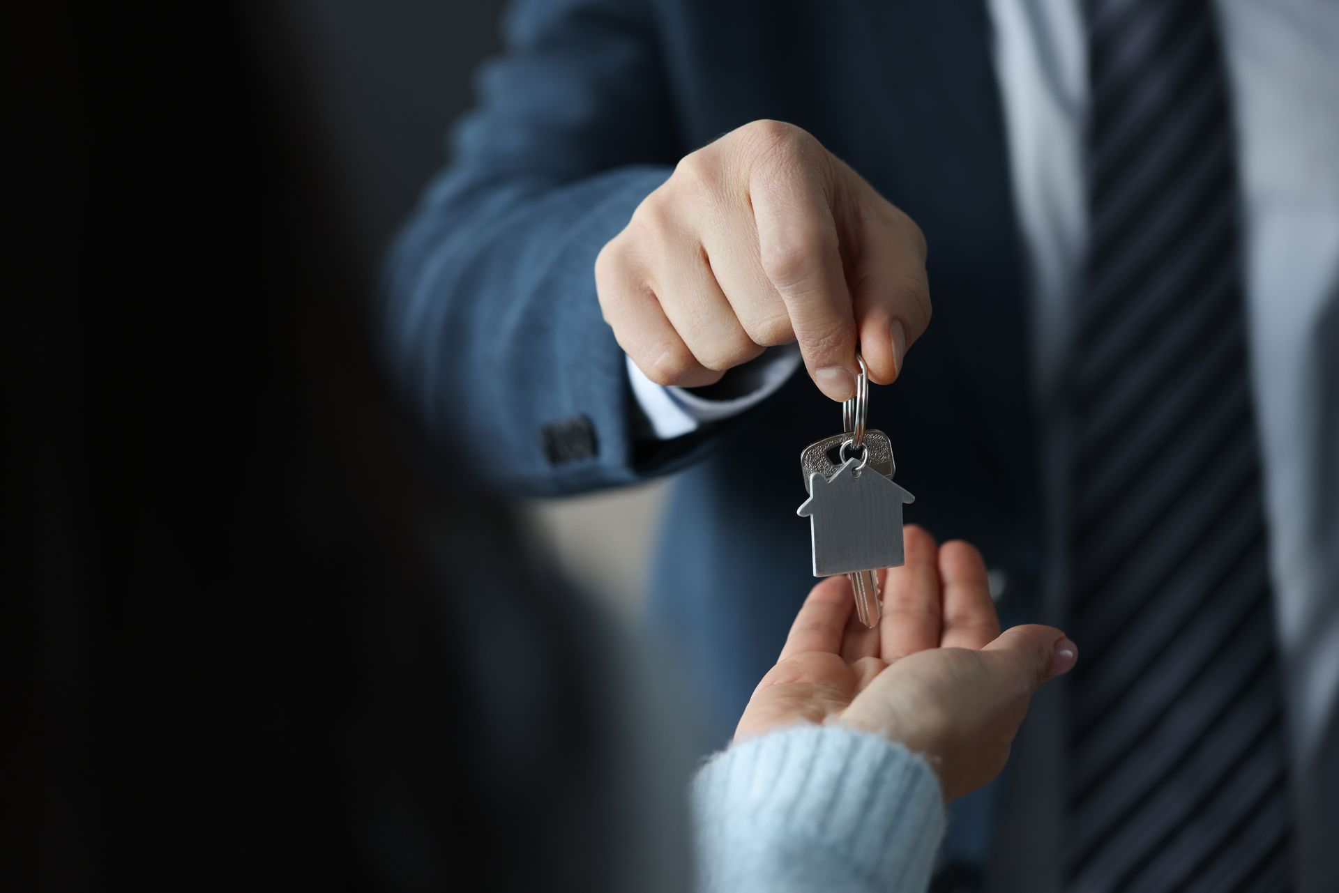 Businessman hands over house keys to client.