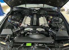 A close up of a car engine with the hood open.