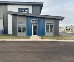 A blue and gray building with a door and a walkway leading to it.