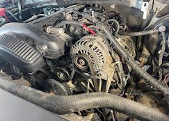 A close up of a car engine with a alternator.