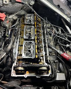 A close up of a car engine with a screwdriver in it.