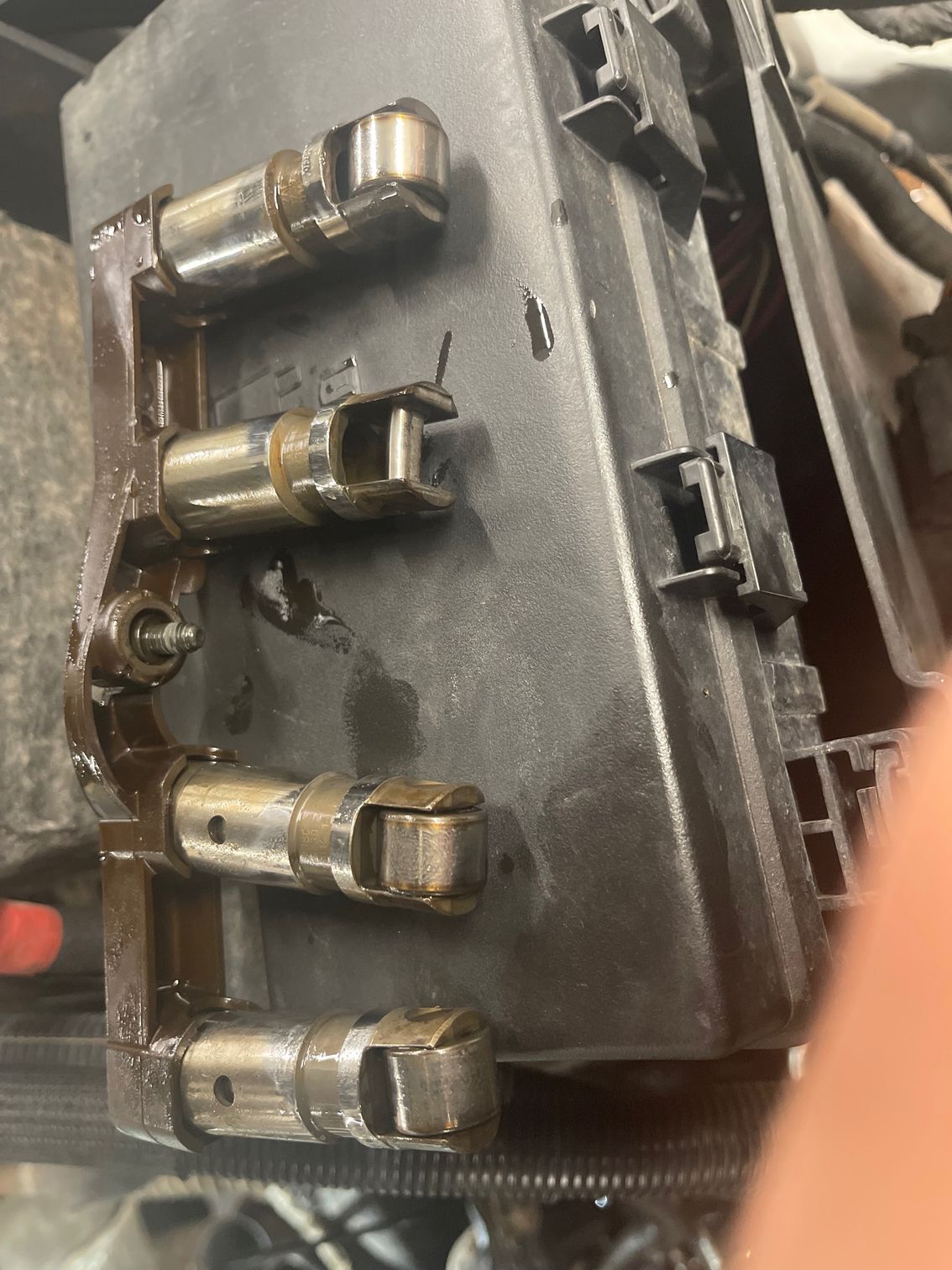 A person is holding a box with a bunch of metal parts on it.