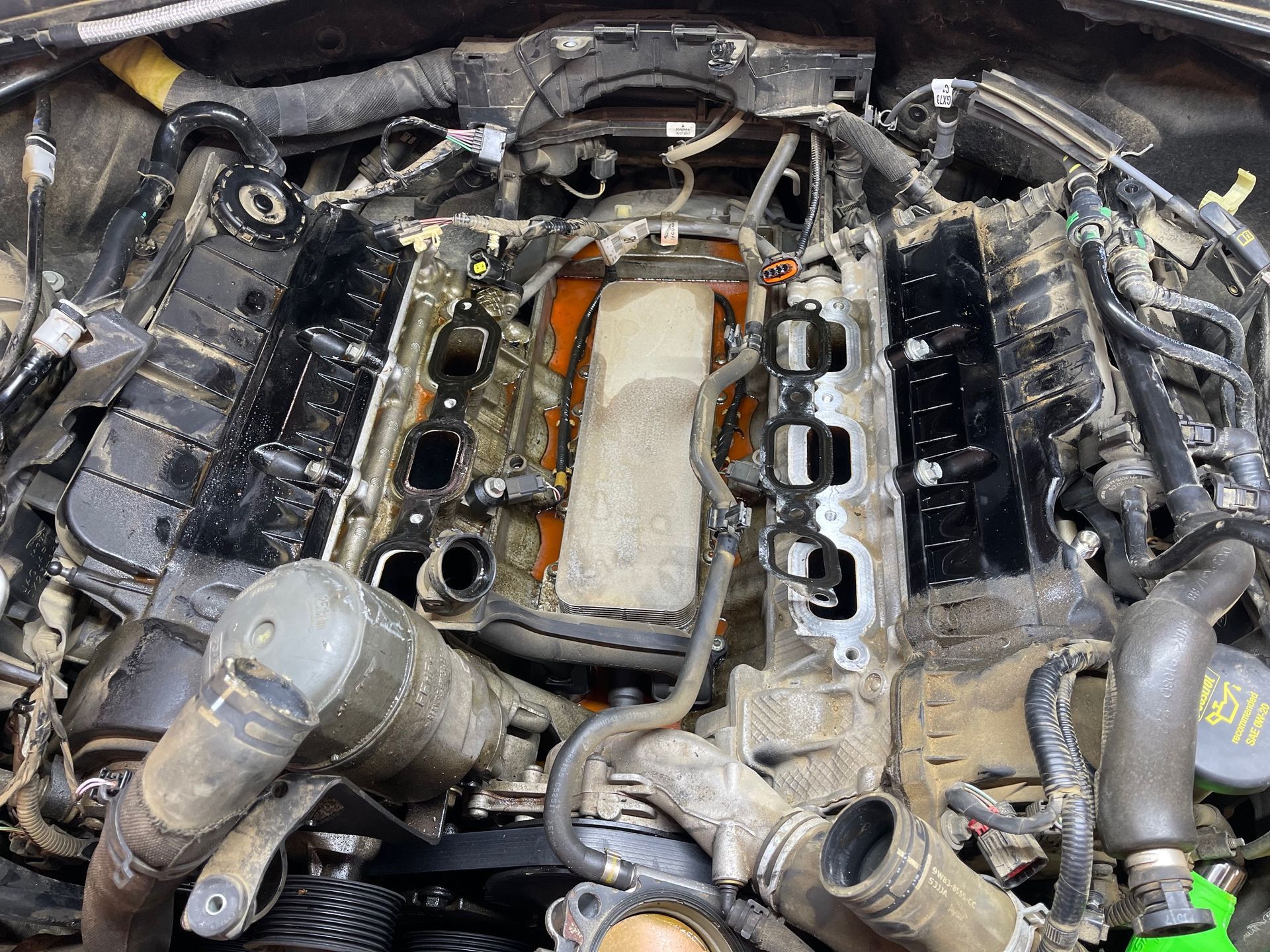 A close up of a car engine with the hood removed.