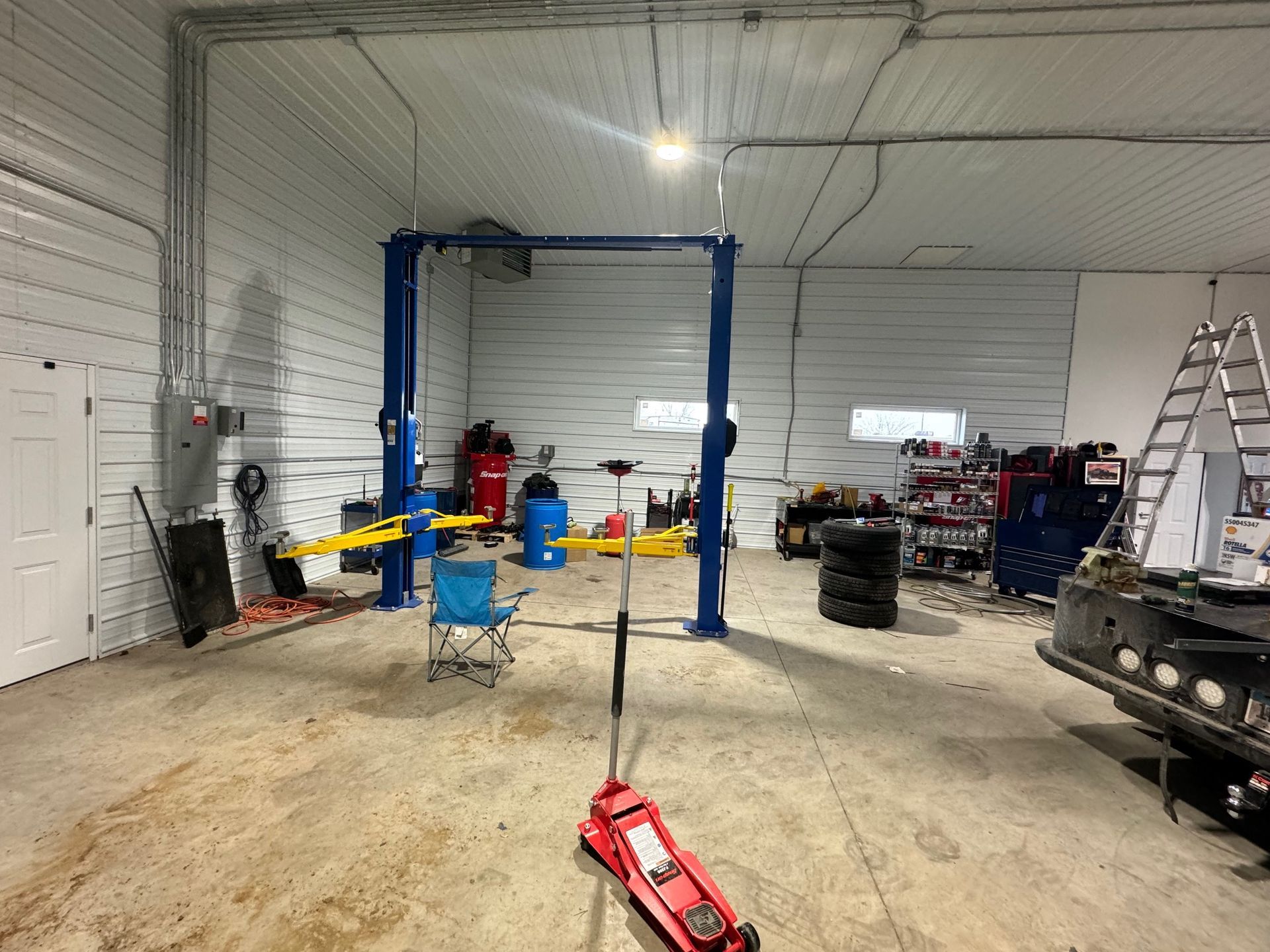 A garage with a lift and a chair in it.
