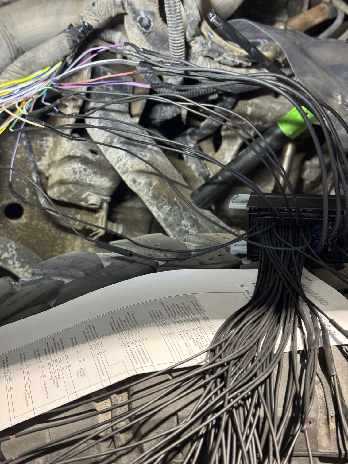 A bunch of wires are laying on the ground next to a piece of paper.