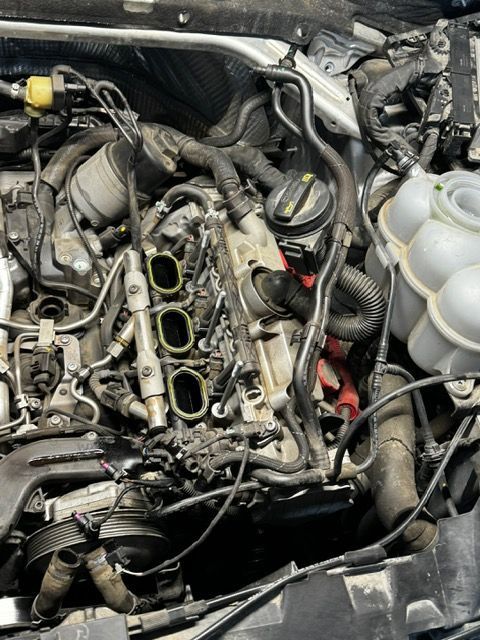 A close up of a car engine with the hood open