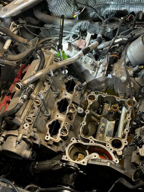A close up of a car engine being worked on.