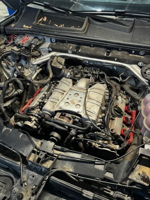 A close up of a car engine with the hood open.