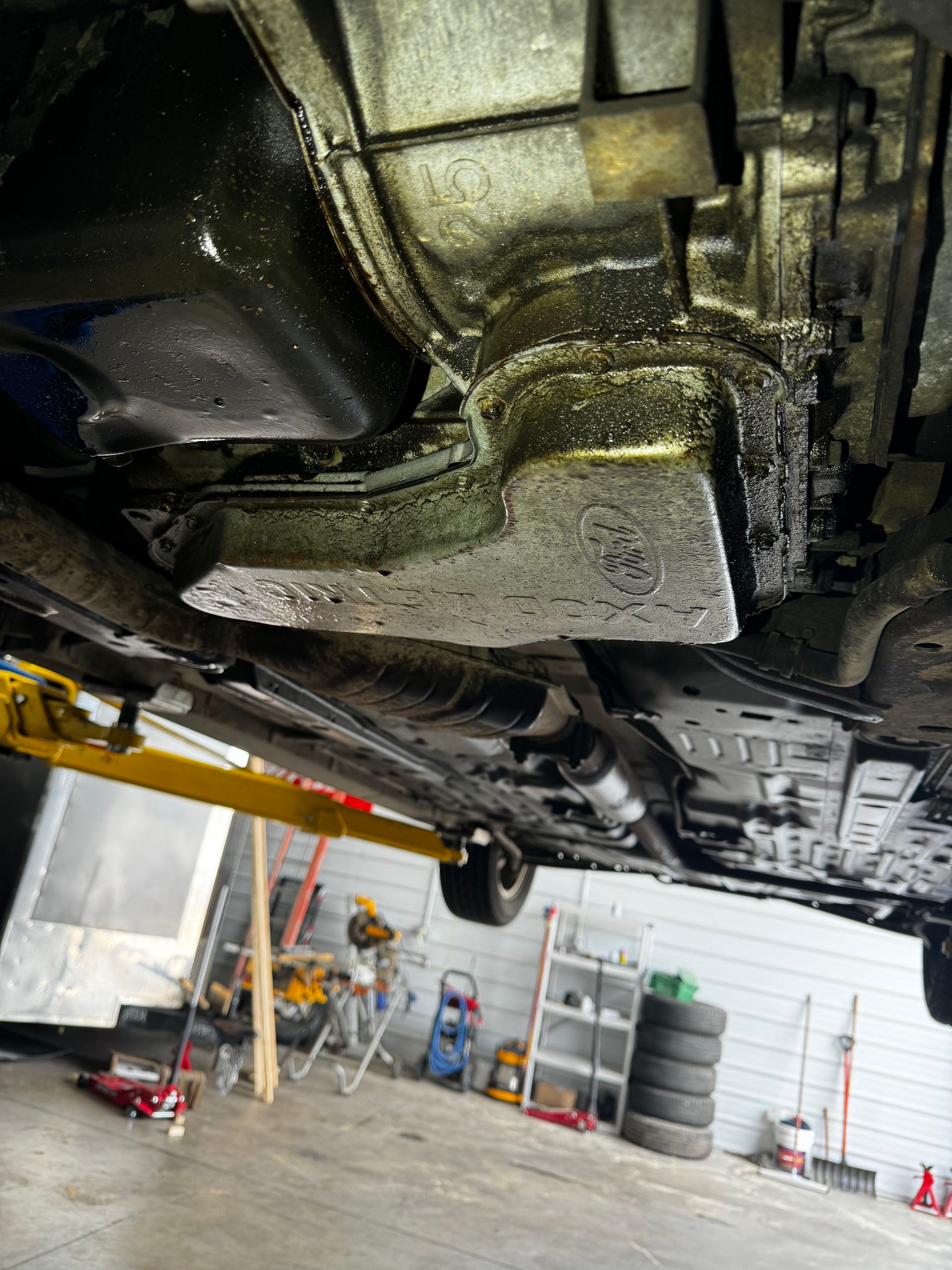 A car is sitting on a lift in a garage.