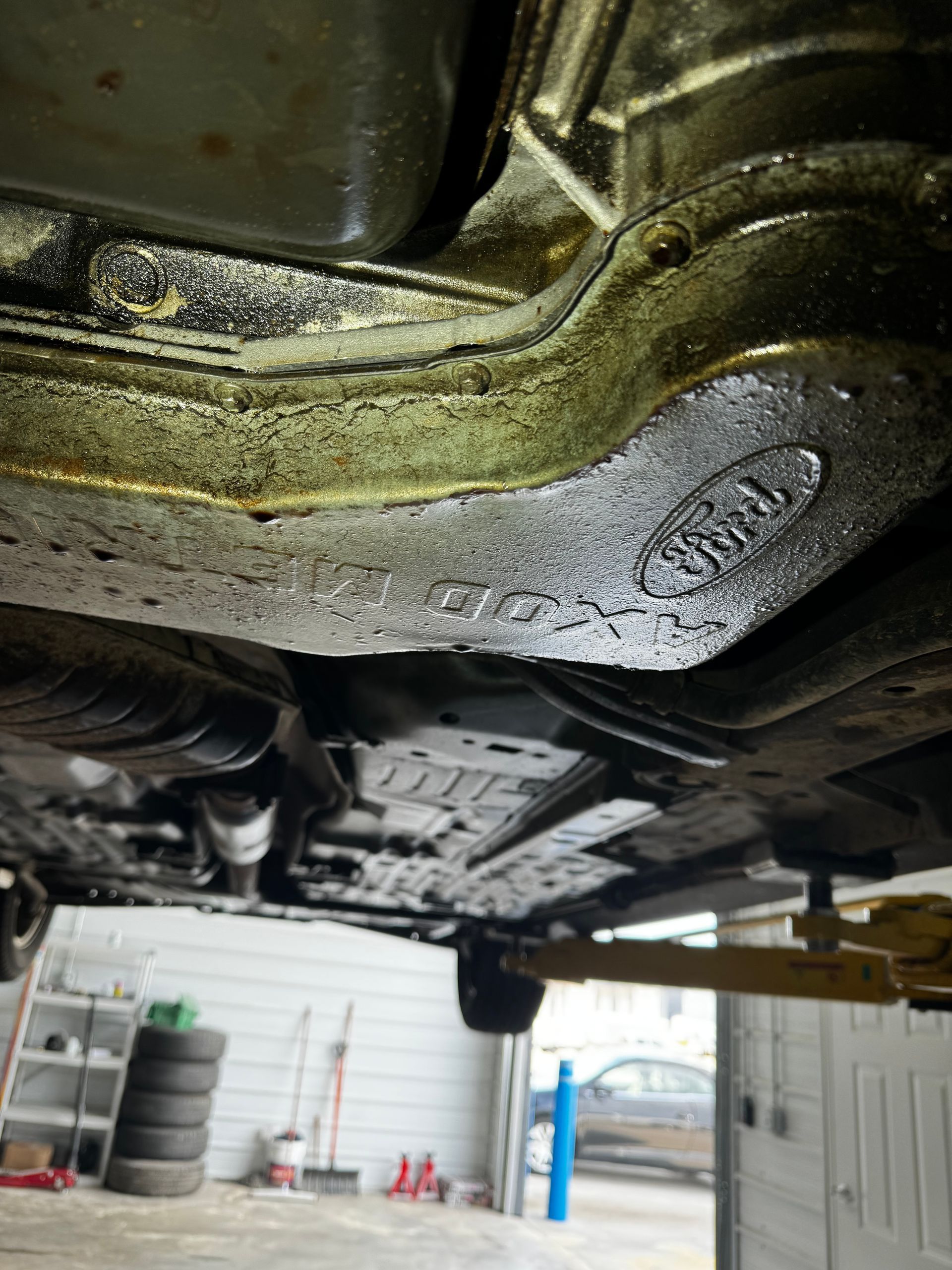 A car is sitting on a lift in a garage.