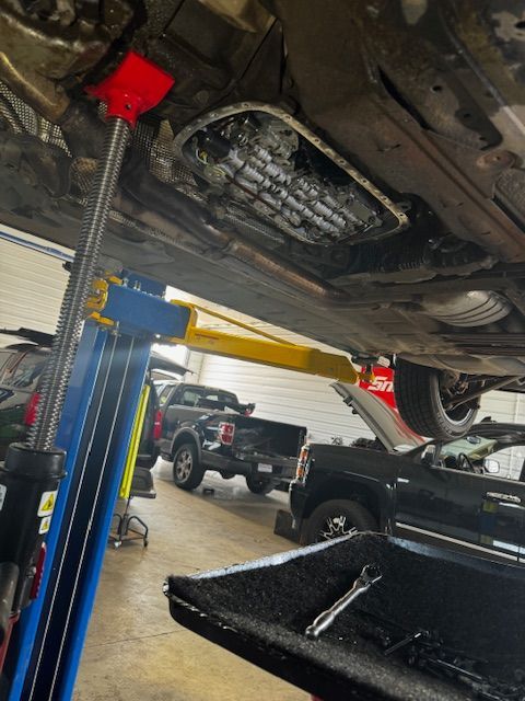 A car is sitting on a lift in a garage.