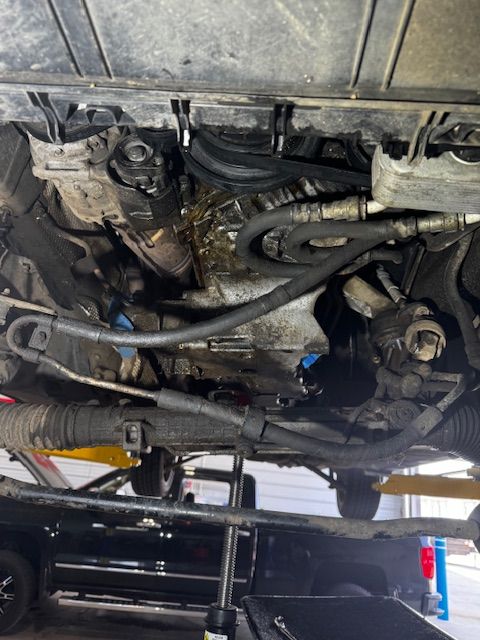 The underside of a car is shown in a garage.