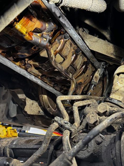 A close up of a car engine with a lot of wires coming out of it.