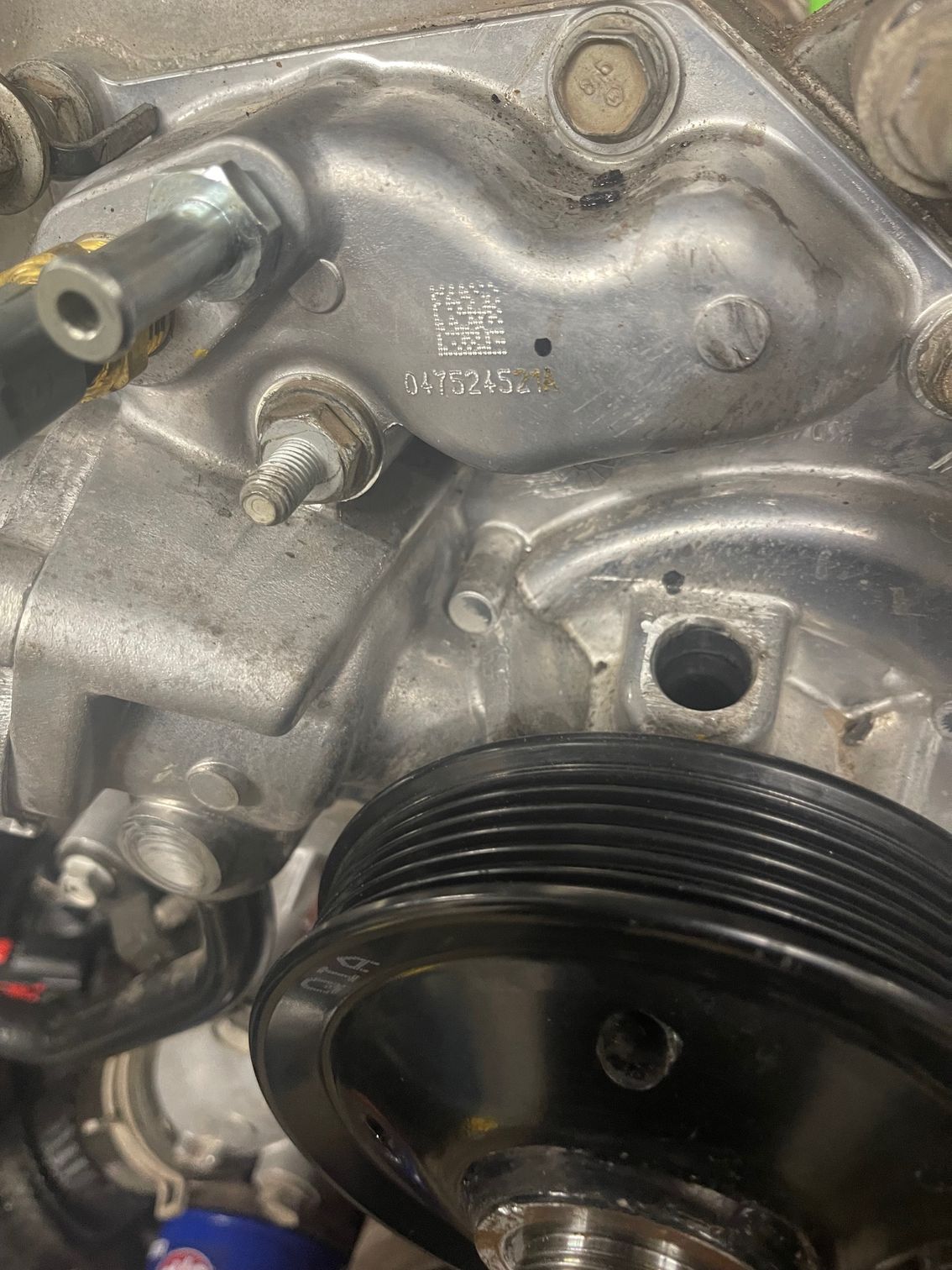 A close up of a water pump on a car engine.