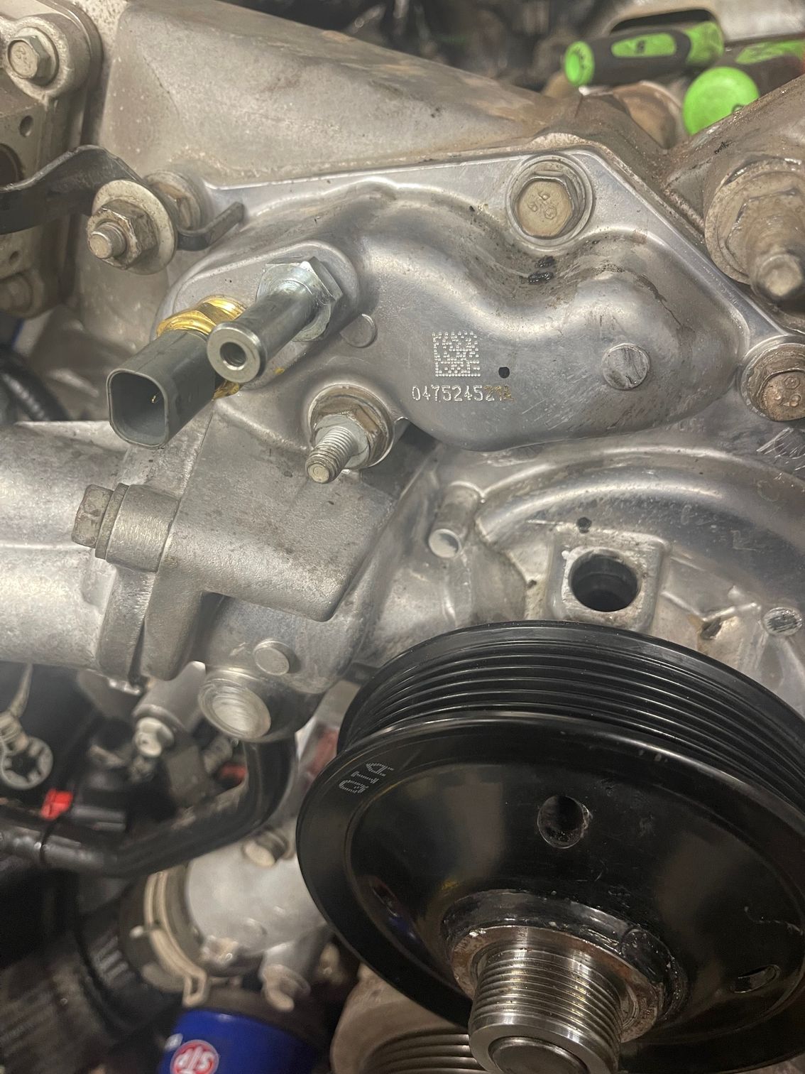 A close up of a water pump on a car engine.