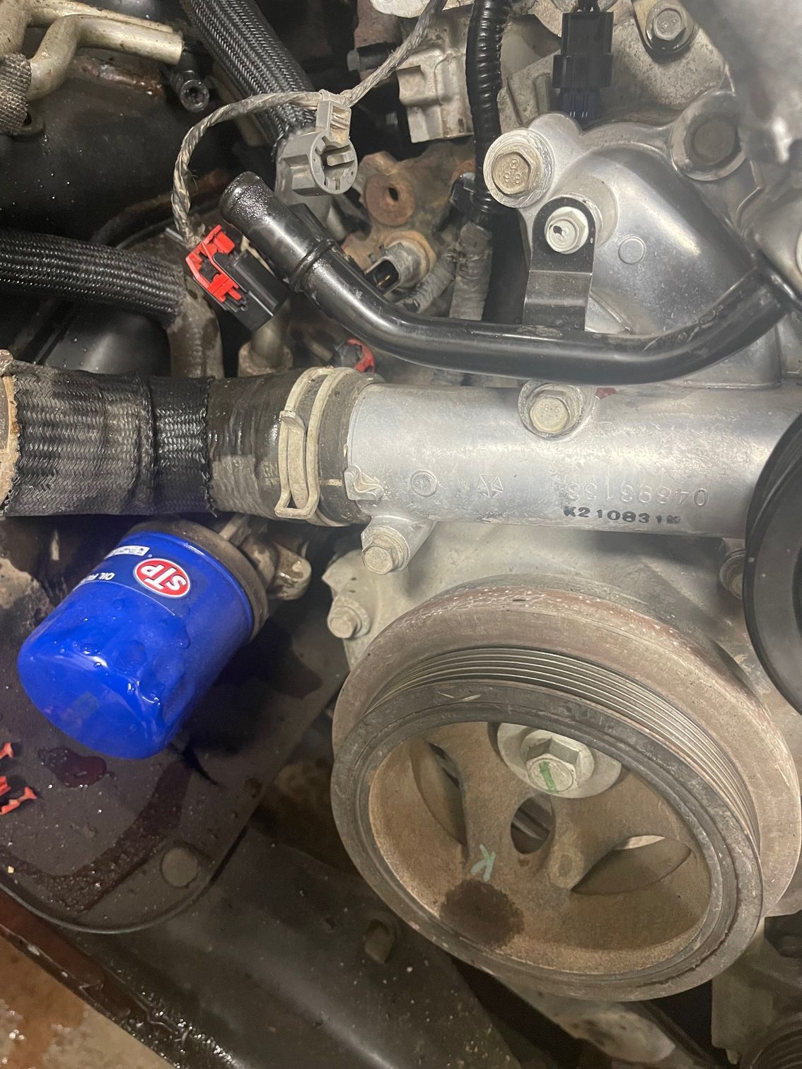 A close up of a car engine with a blue oil filter attached to it.