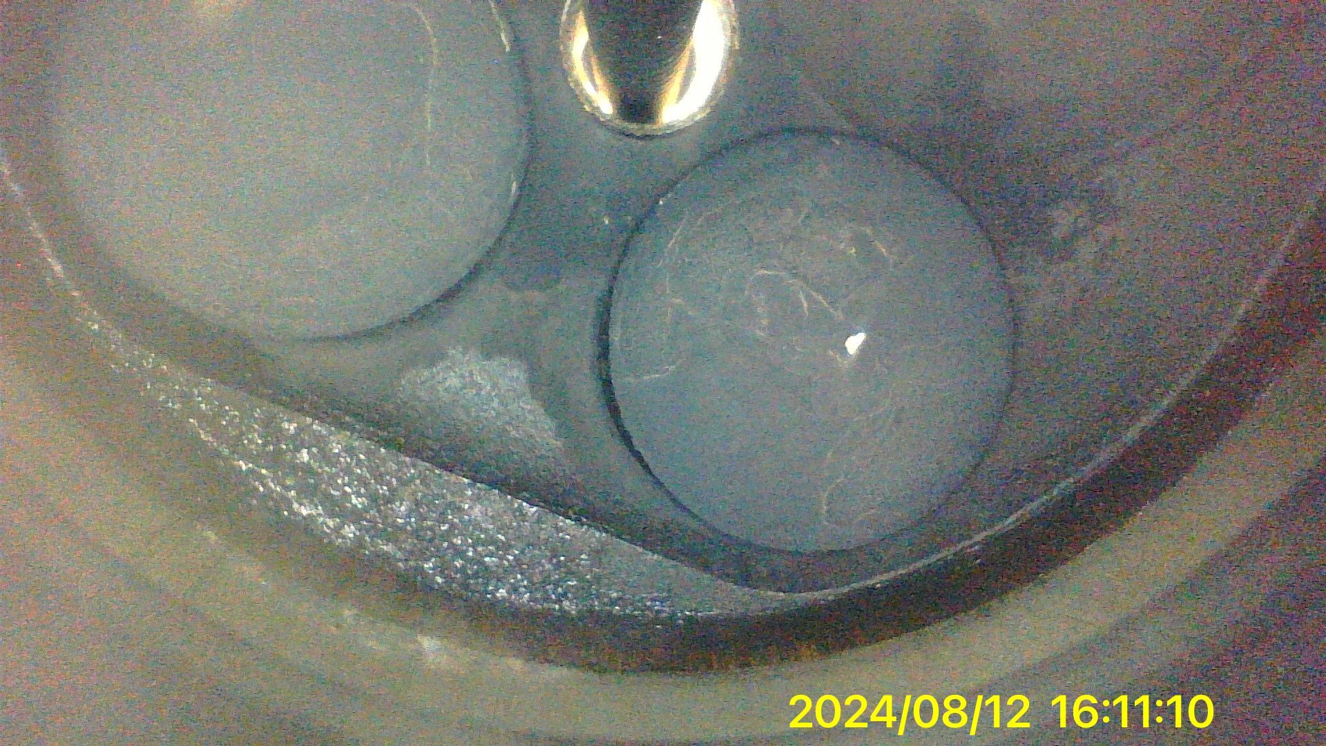 A close up of a metal object with a clock on it.