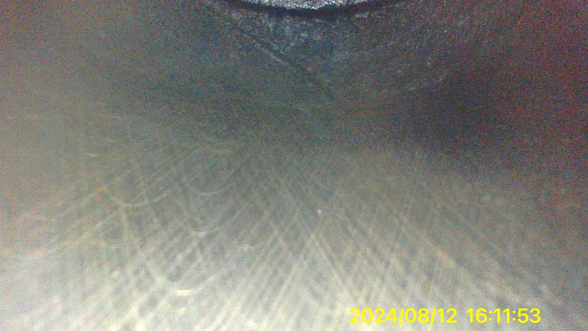 A close up of a gray surface with a yellow watermark on it.