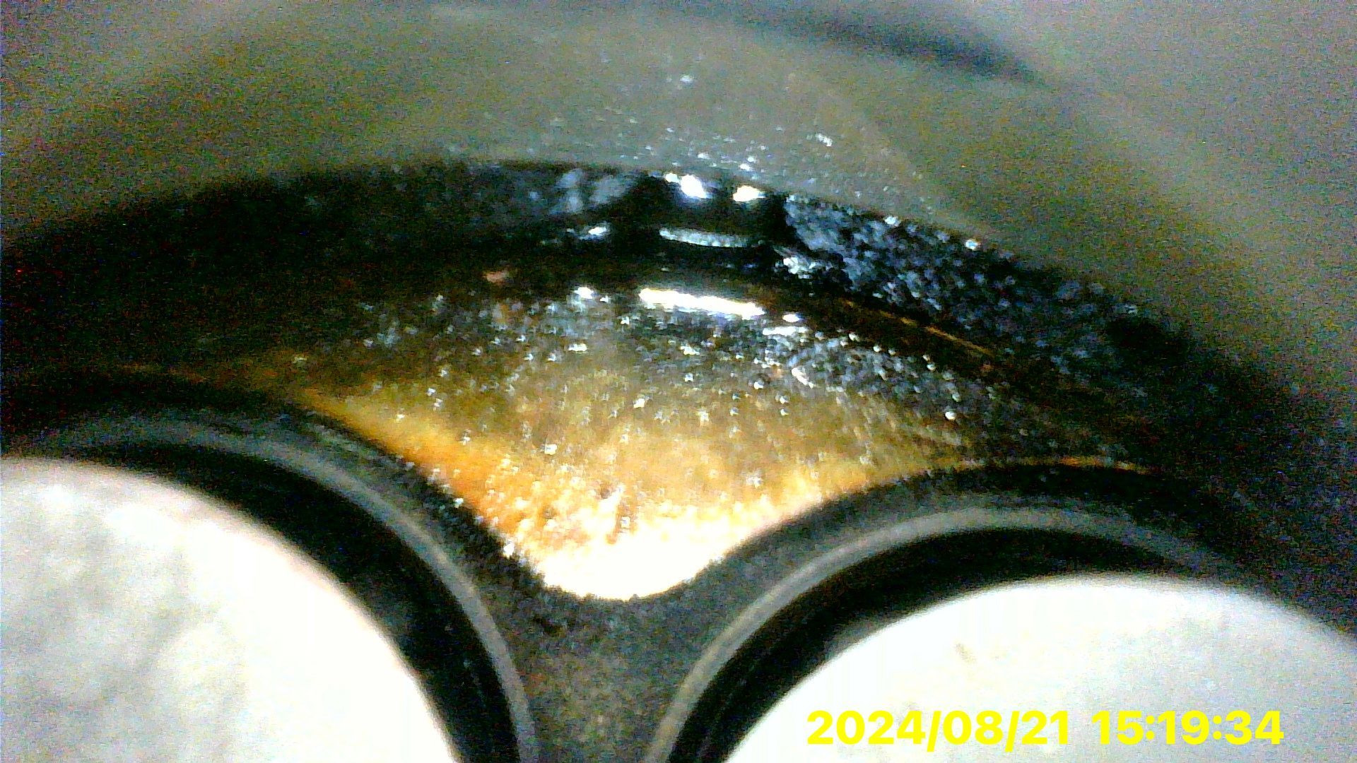 A close up of a black object with a yellow watermark that says ' 2024/08/21 ' on it.