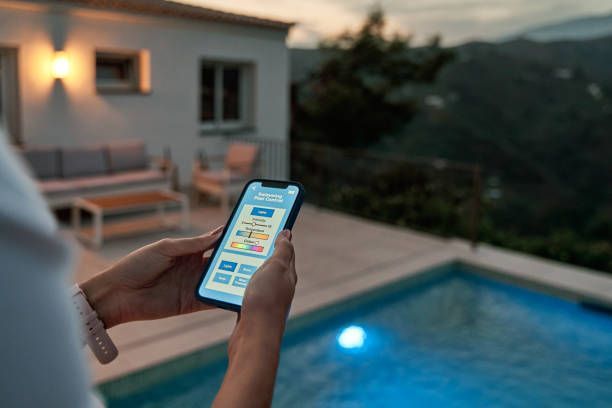 A person is using a smart phone to control a swimming pool.