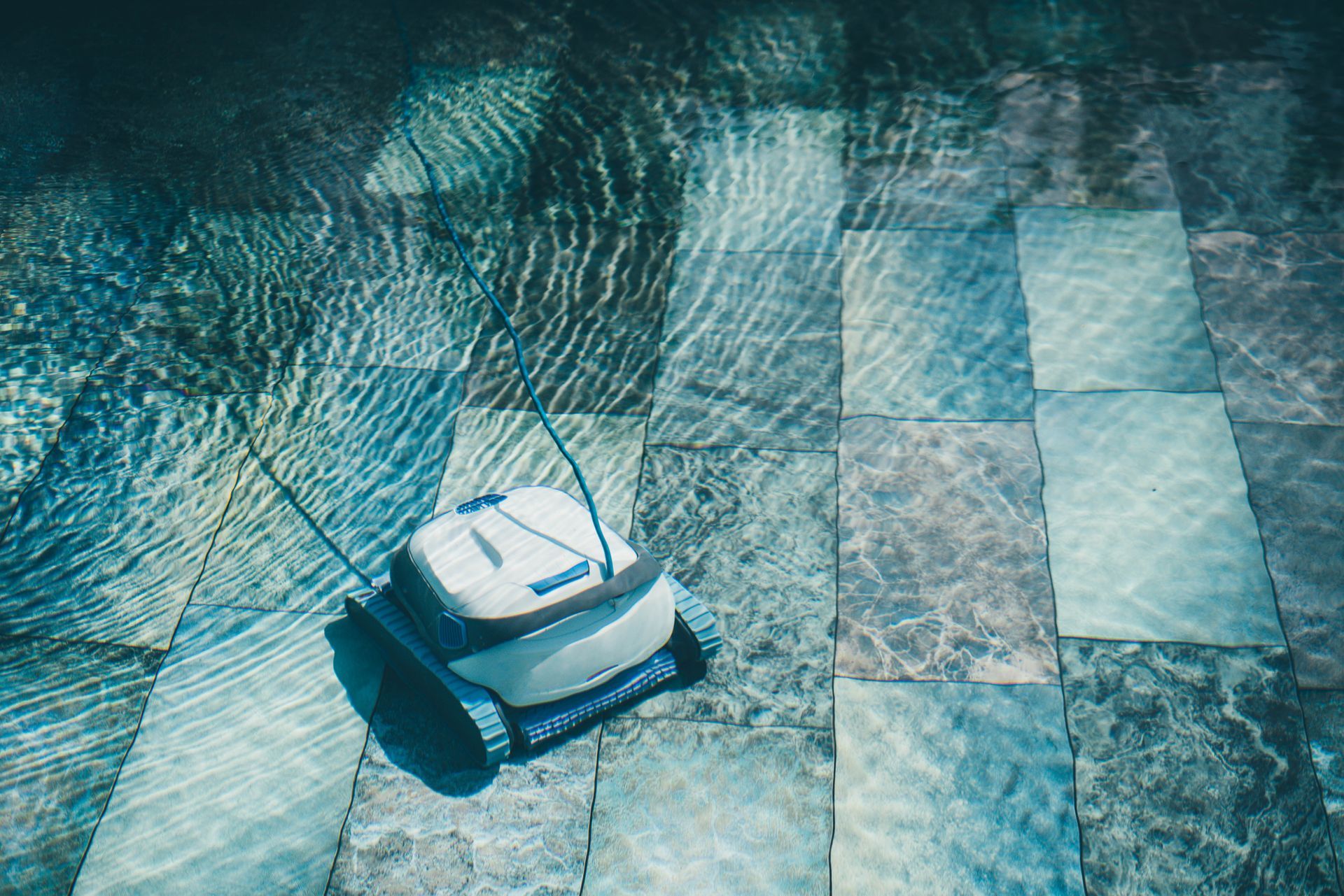 A robotic vacuum cleaner is floating in a swimming pool.